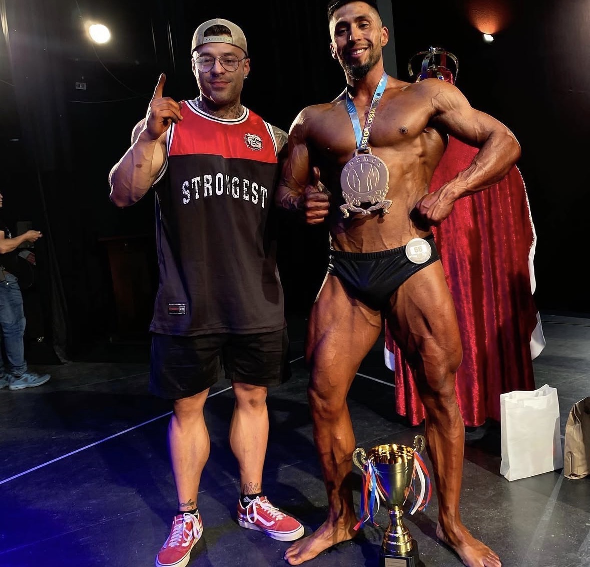 Coach junto a atleta con copa